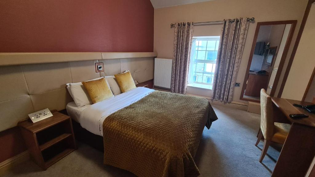 卡文The Farnham Arms Hotel的酒店客房设有床和窗户。