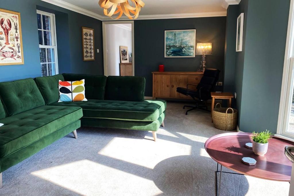 特鲁罗Riverside Idyll - the perfect Cornish Sanctuary的客厅配有绿色沙发和桌子