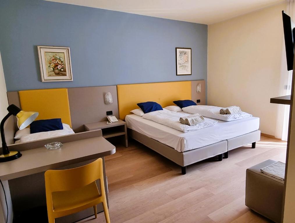 阿科圣乔治酒店的客房设有两张床、一张桌子和一张书桌。