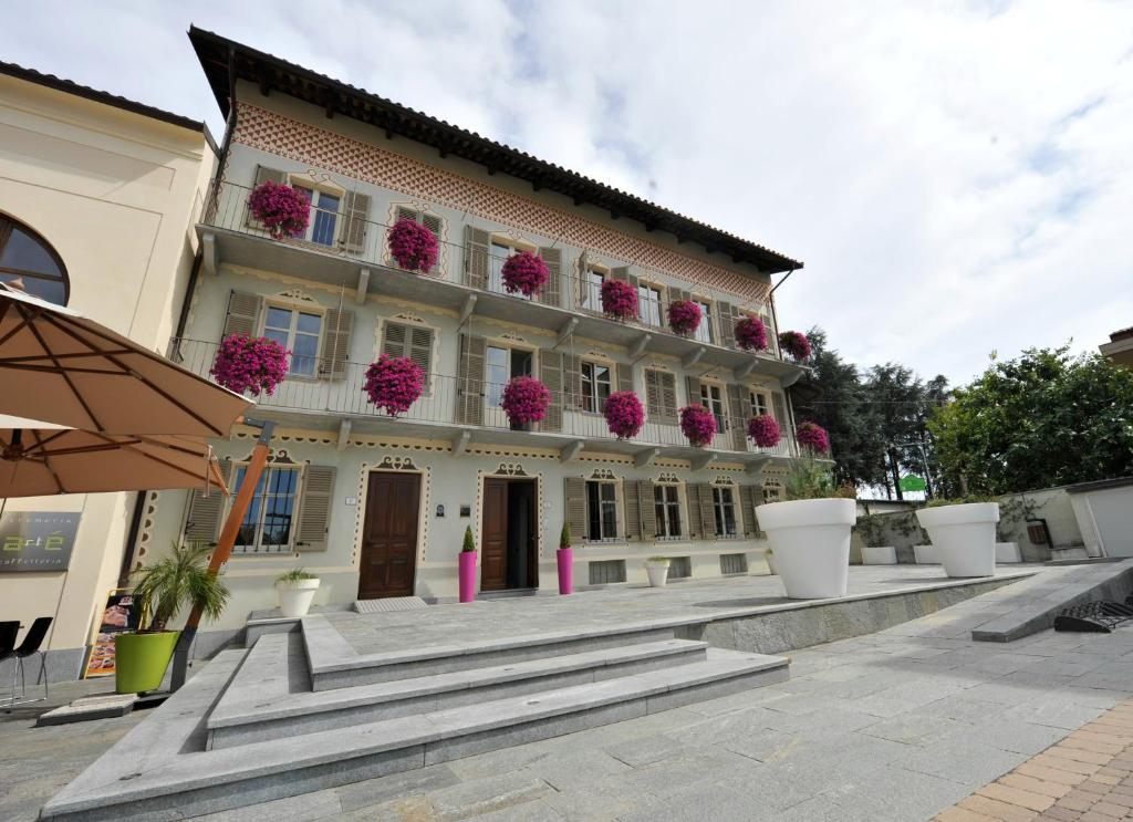 Montà卡萨阿梅日卡尼酒店的前方有粉红色花的建筑