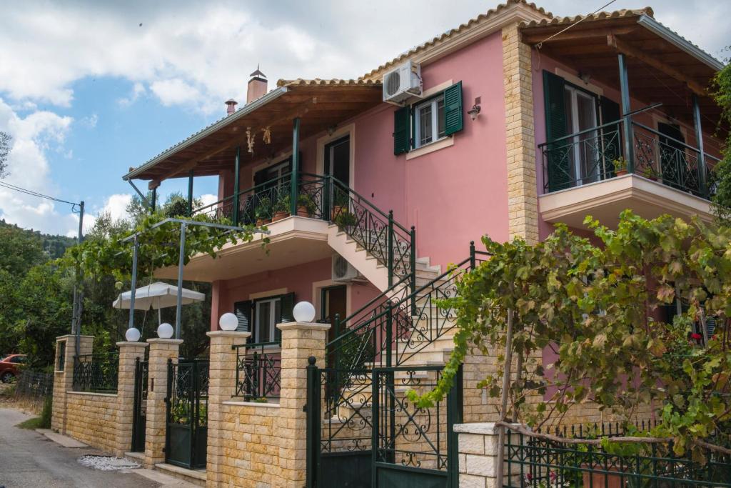 尼基亚娜Anna's Apartments的粉红色的房子 - 带阳台