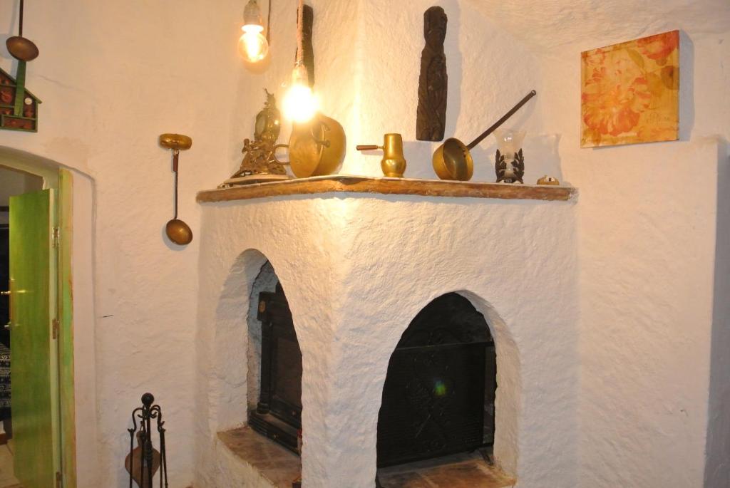 瓜迪克斯Casa cueva El Algarrobo的一间设有白色墙壁的壁炉