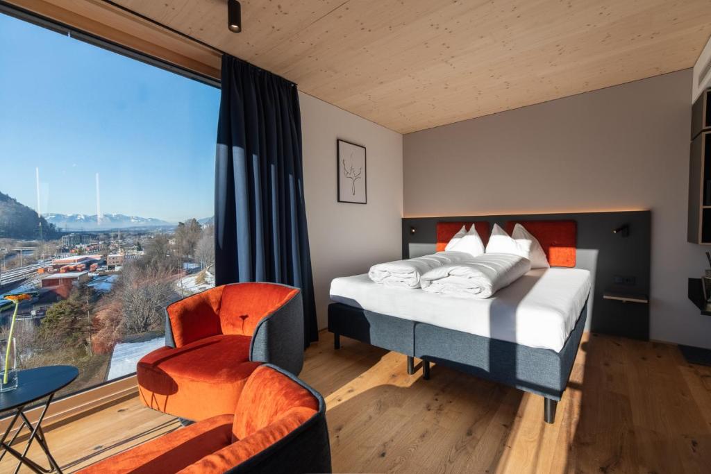 布鲁登茨ALPSTADT LIFESTYLE Hotel的一间卧室设有一张床和一个大窗户