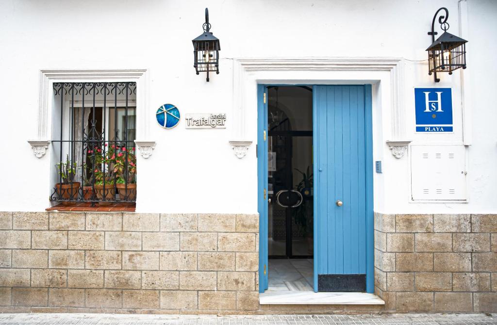 巴尔巴特Hostal Trafalgar的白色建筑上一扇蓝色的门,有窗户