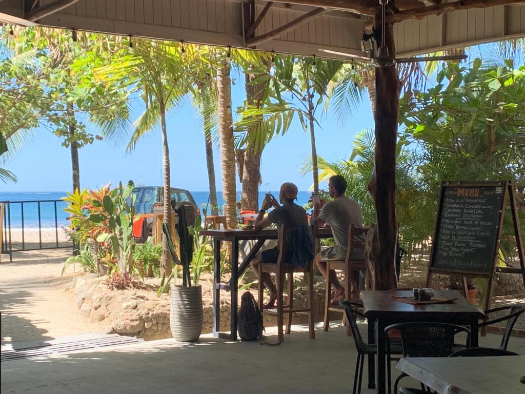 萨玛拉Beach Front Bahia的两个人坐在一张桌子上,看着大海