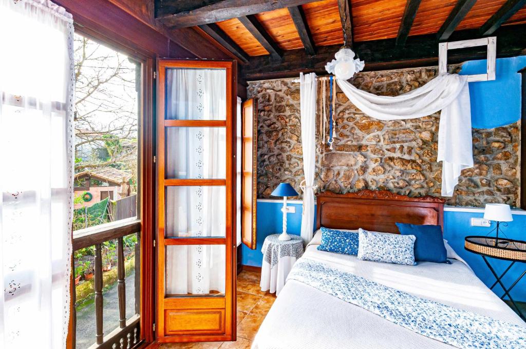 利亚内斯Casa Conce Zona de playa y montaña的一间卧室设有一张床和石墙