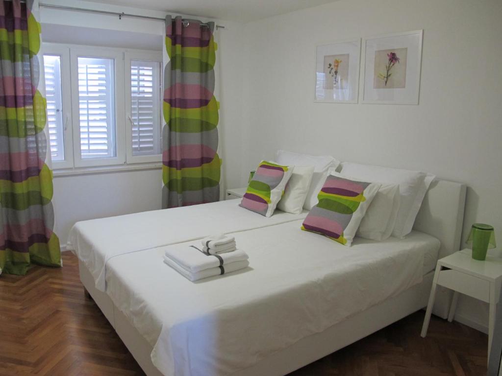 科尔丘拉科尔丘拉菲欧力诺旅馆的卧室配有一张白色大床,里面装有书籍