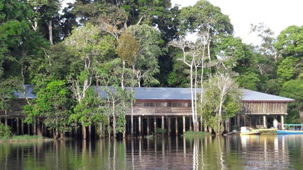 莱蒂西亚AMAZONAS RESERVA Yavary Tucano的水体上座的建筑物