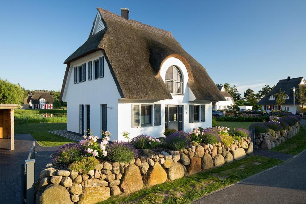富伦多夫Ferienhaus Schilfrohrsaenger 54的白色的小房子,带有茅草屋顶