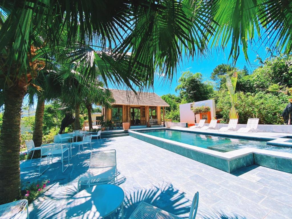 河内ROSE Villas & Resort - Ba Vi的一个带椅子的游泳池以及一座房子