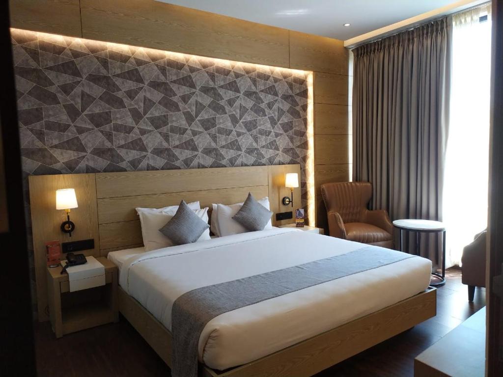 德里久尔MothiMahal Residency Thrissur的一间位于酒店客房内的带大床的卧室