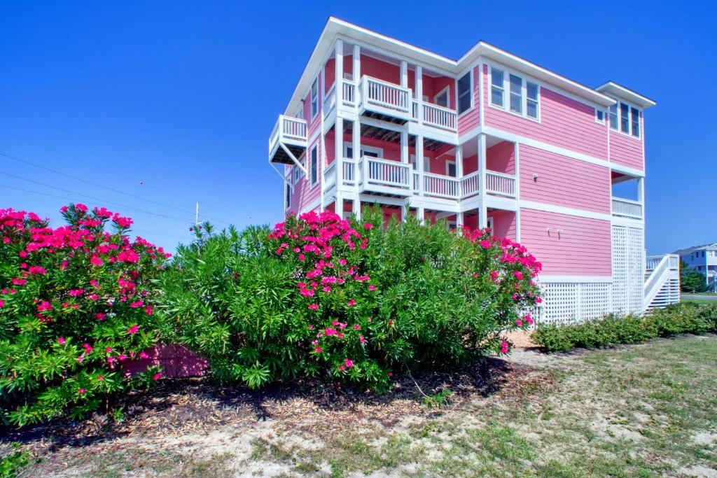 罗丹特San Flamingo 486的粉红色的房子,前面有粉红色的花朵