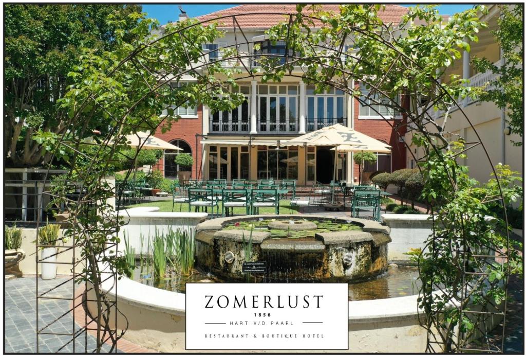 帕尔Zomerlust Boutique Hotel的一座花园,在一座建筑前方有一个喷泉
