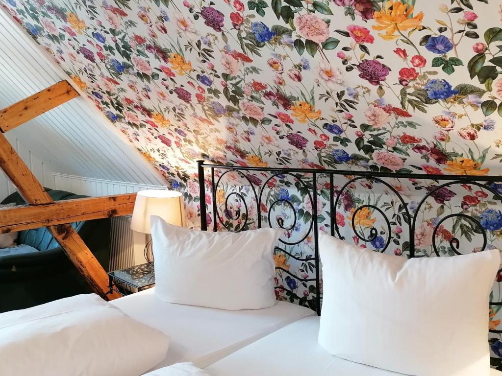 布罗特罗德Pension Pfefferstübchen的一间卧室设有华丽的墙壁和一张带两个枕头的床。