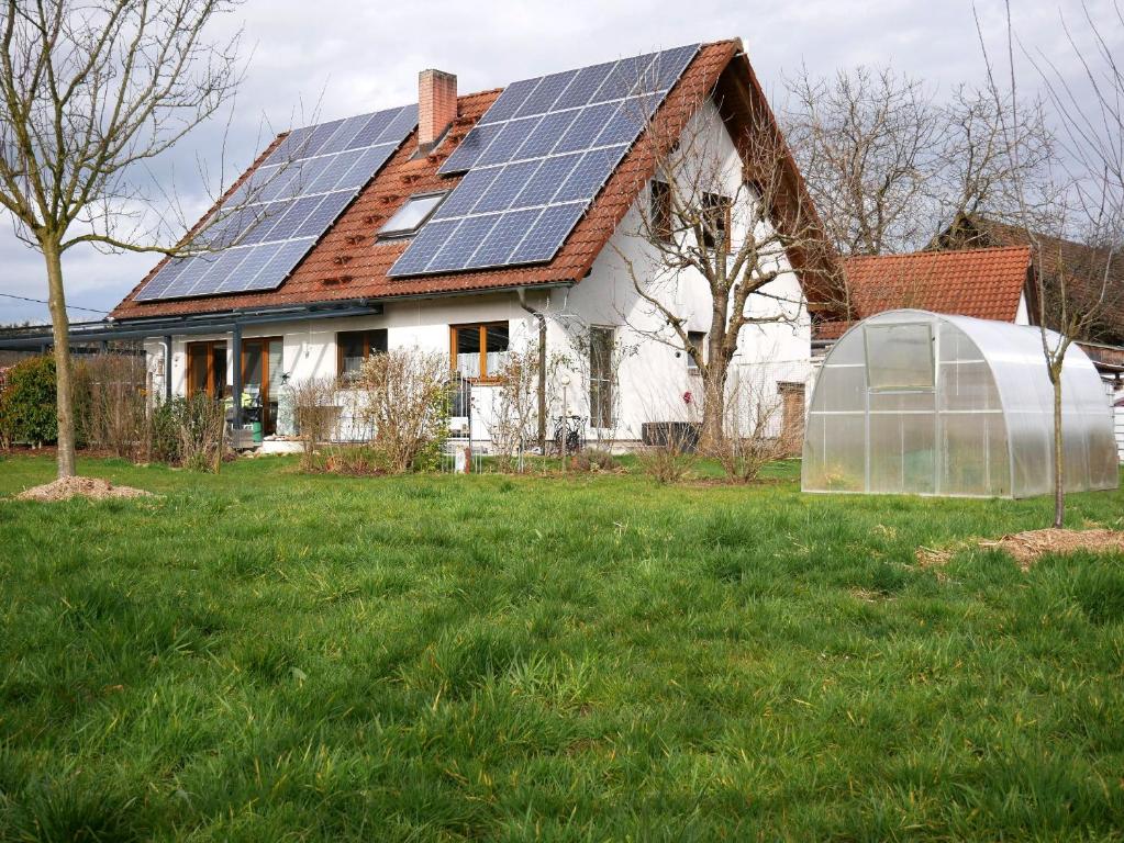 奥伯基希Ferienwohnung Obere Alm的屋顶上设有太阳能电池板的房子和温室