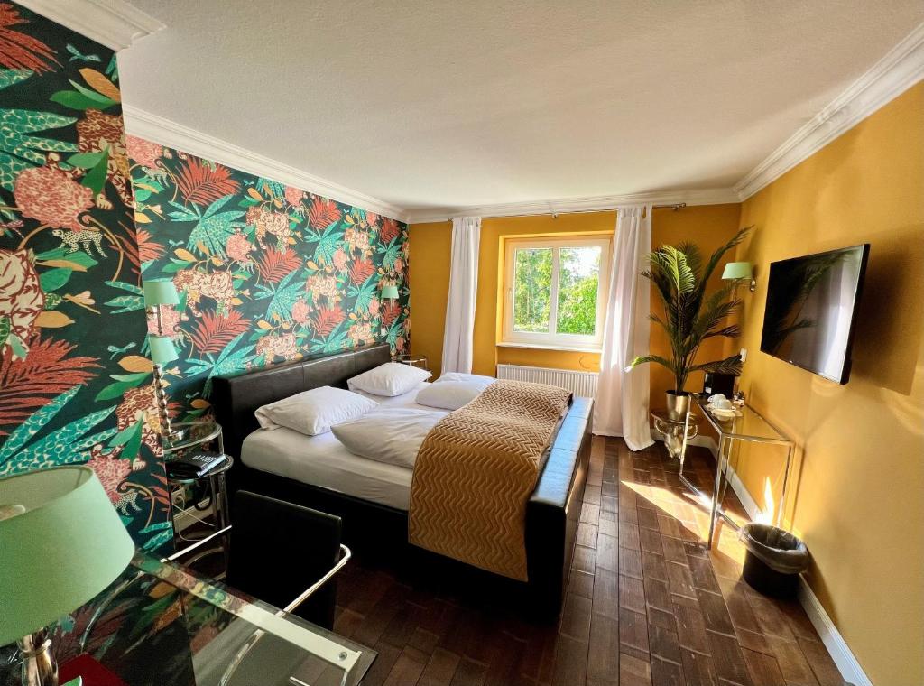 杜塞尔多夫埃什里花园酒店的一间卧室配有一张带花卉壁纸的床