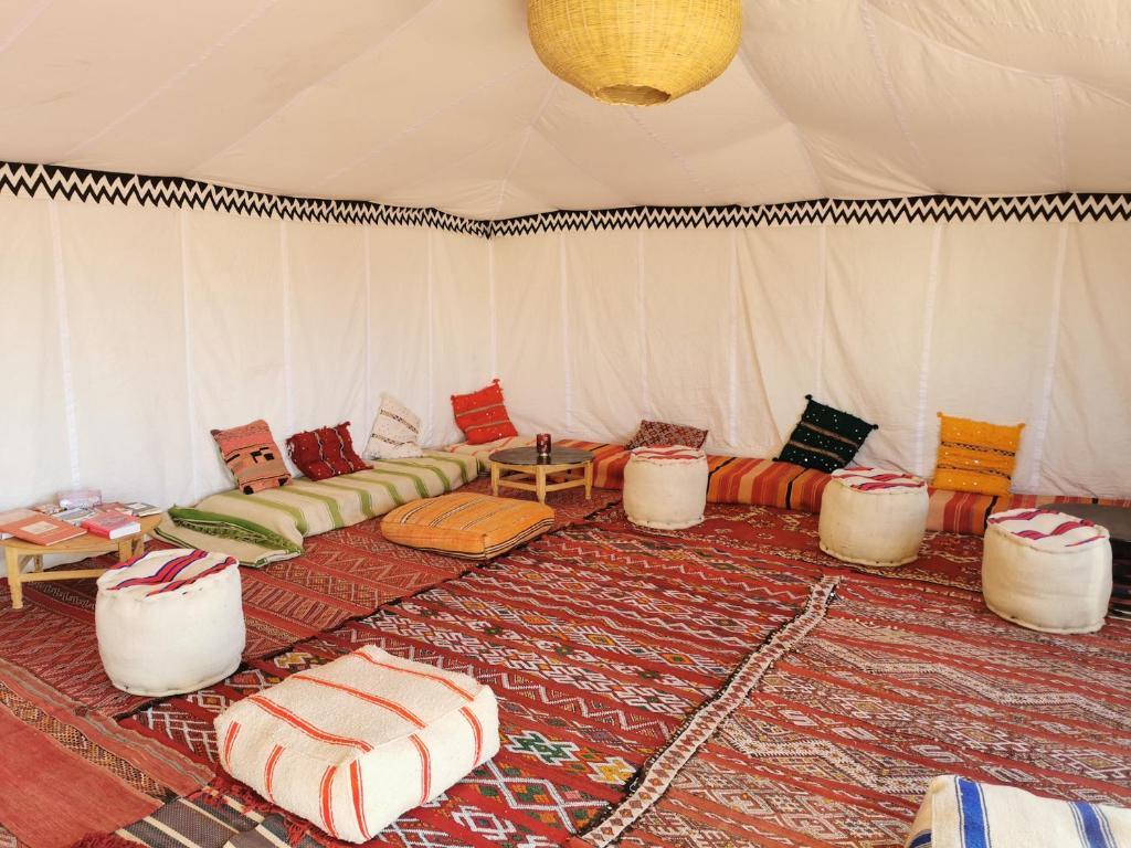 El GoueraBivouac Erg Chegaga Nomademoi的一间带沙发和桌子的帐篷的房间