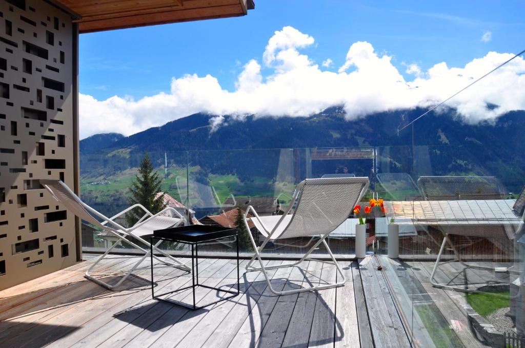 VellaCASA LUMNEZIA - Panoramic Ecodesign Apartment Obersaxen - Val Lumnezia I Vella - Vignogn I near Laax Flims I 5 Swiss stars rating的一个带桌椅的山景阳台