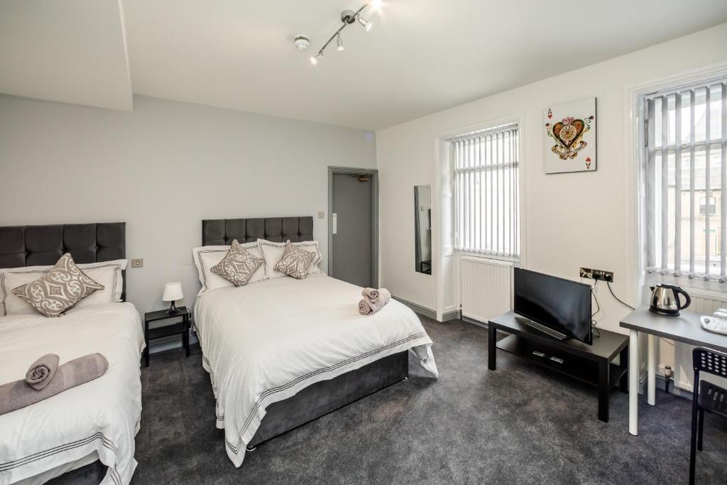 哈德斯菲尔德Huddersfield Central Lodge的一间卧室配有两张床和一台平面电视