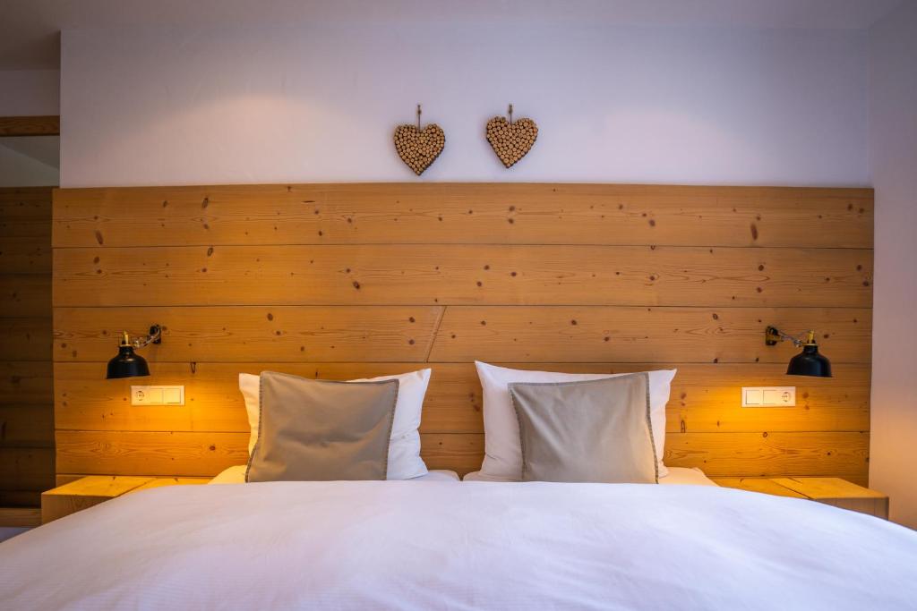 蒂蒂湖-新城MINAROSO appartements am badeparadies -ehemalig Kaltenbachs Appartements的卧室配有一张带两个枕头的大白色床