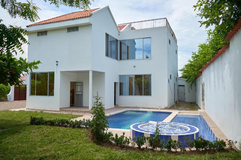 吉拉尔多特Casa vacacional Girardot 5 habit的一座白色的房子,前面设有一个游泳池