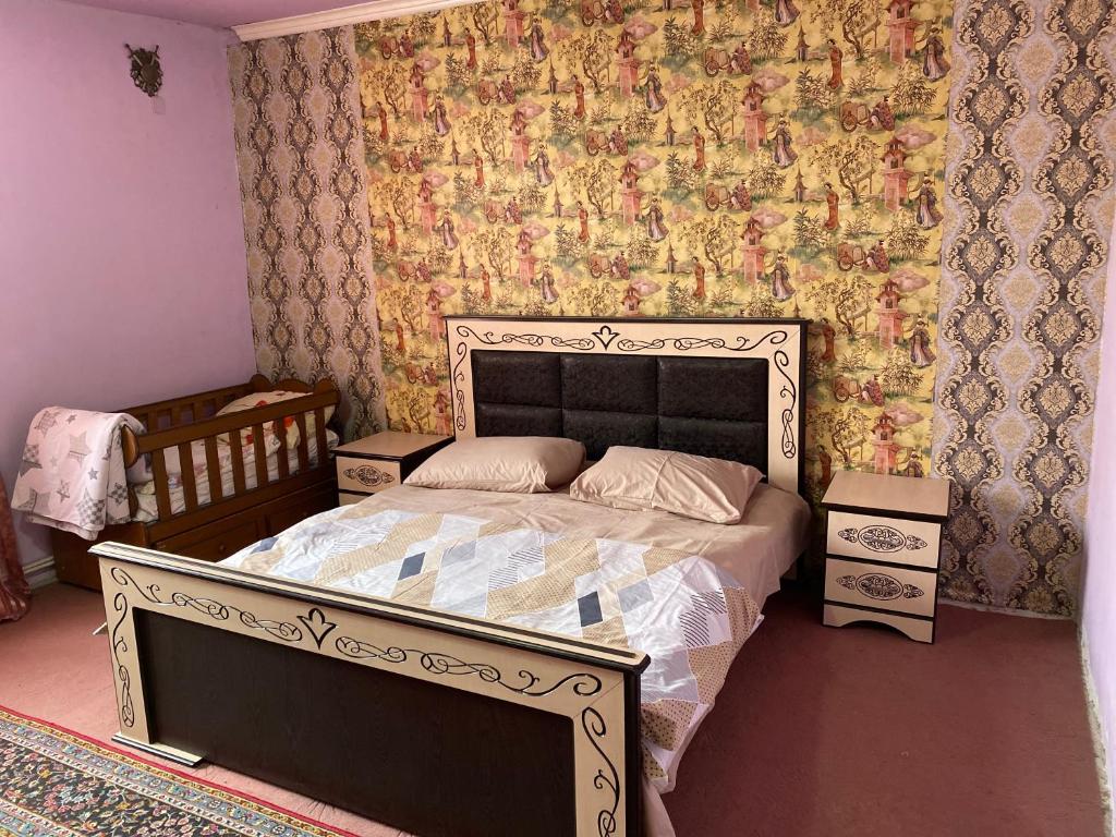 埃里温Friend's House rooms near Airport的一间卧室配有一张床和一张带花卉壁纸的墙壁