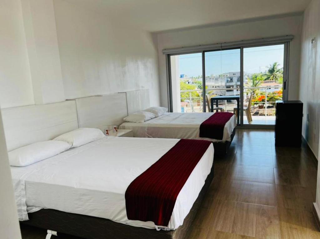 阿约拉港Sumaq House offer a new suite的带大窗户的客房内的两张床