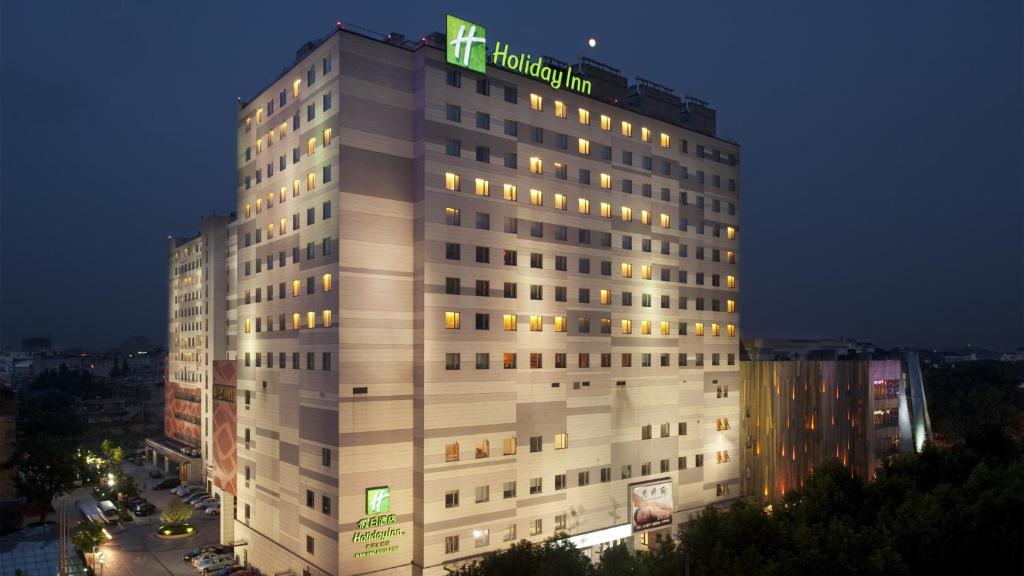 南京南京水游城假日酒店的上面有绿色标志的高大的白色建筑