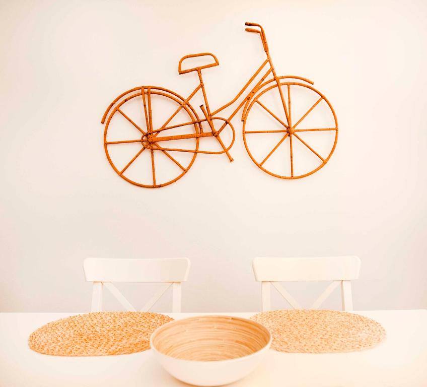 梅拉诺Portico ventizerodue的两把椅子旁挂在墙上的自行车