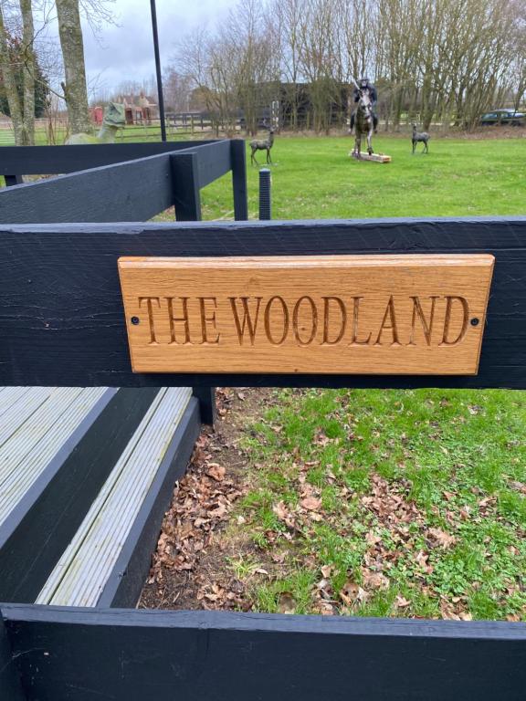 乌波斯顿The Woodland的公园长凳上的一个标志,上面写着林地