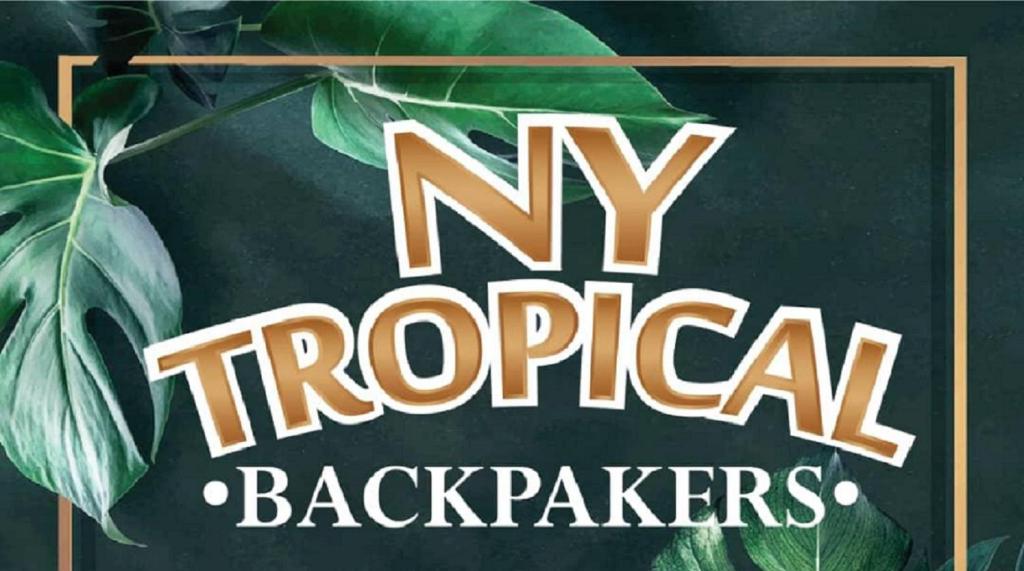 迪沙鲁NY TROPICAL BACKPACKERS的读书的标志,用叶子读我的热带后院