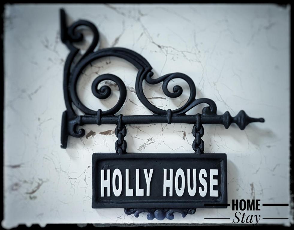 埃拉Holly House Homestay的挂在墙上的软屋标志