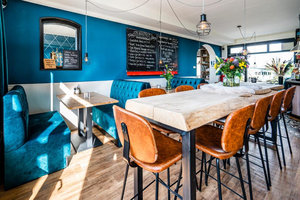 卡德赞德Bruist的一间拥有蓝色墙壁和桌椅的用餐室