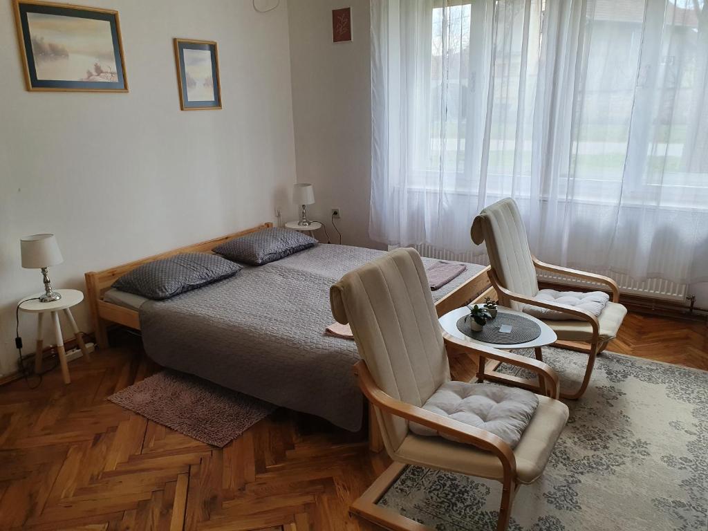 松博尔Citadela的一间卧室配有一张床、两把椅子和一张桌子