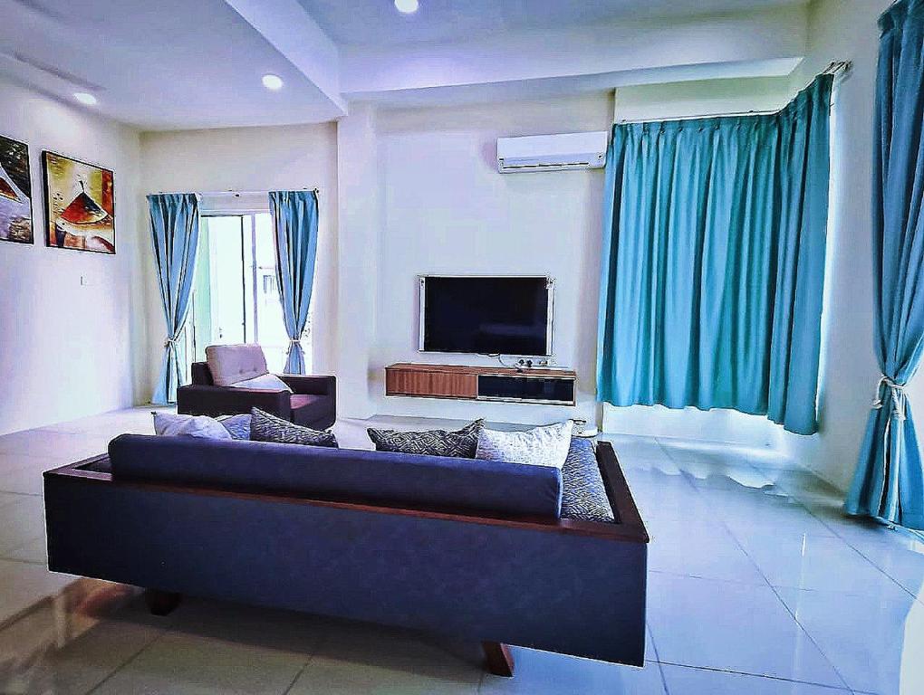 瓜埠GUESTHOUSE #1 SEMI Bungalow House的客厅配有蓝色的沙发和电视