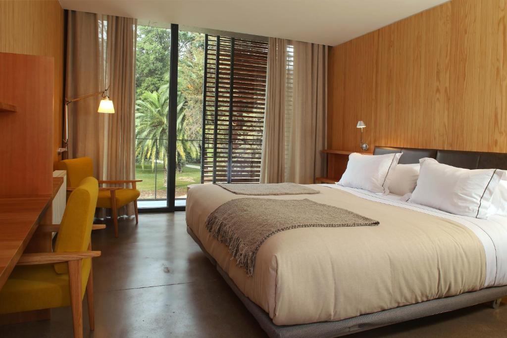 皮尔克Las Majadas Hotel & Centro de Reuniones的一间卧室设有一张大床和大窗户