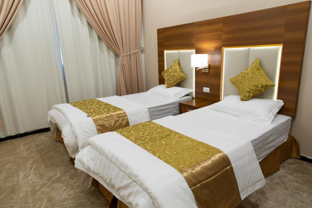 哈伊勒الليل لك للشقق الفندقيه的酒店客房设有两张床和窗户。