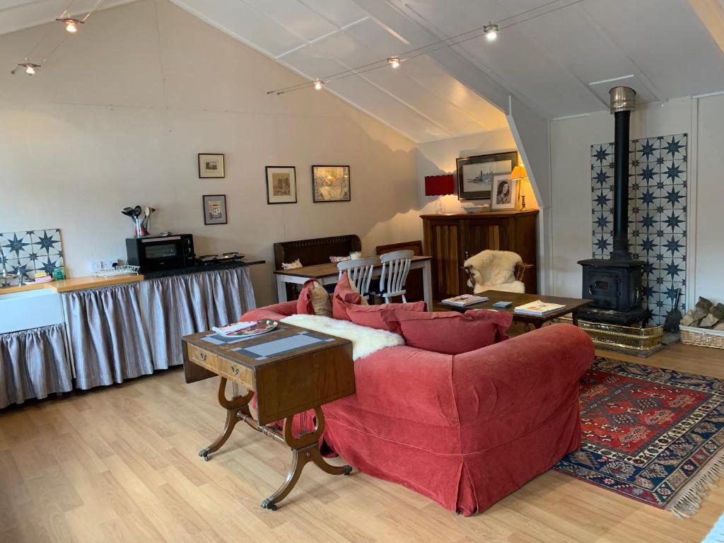 康格尔顿One bedroom lodge in the countryside的客厅配有红色的沙发和桌子