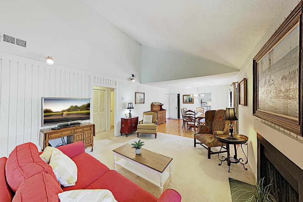 基洼岛442 Oceanwoods的客厅配有红色的沙发和桌子