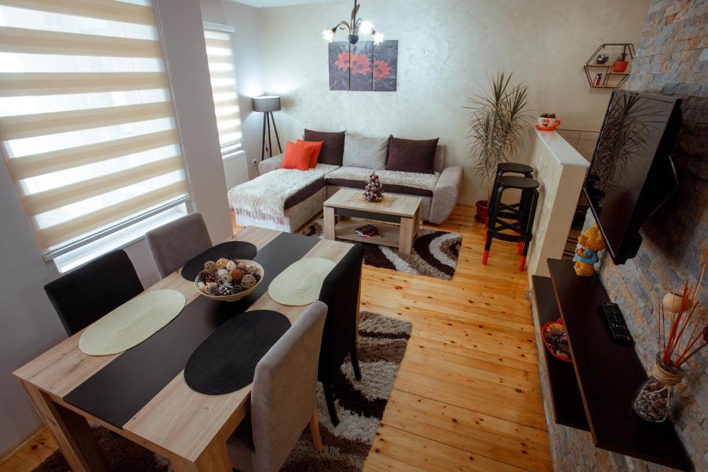 新瓦罗什Apartman Marija的客厅配有桌子和沙发