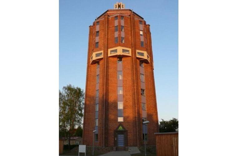 居斯特罗Holiday flat im Wasserturm Güstrow - DMS01100b-P的一座高大的砖砌建筑,有钟楼