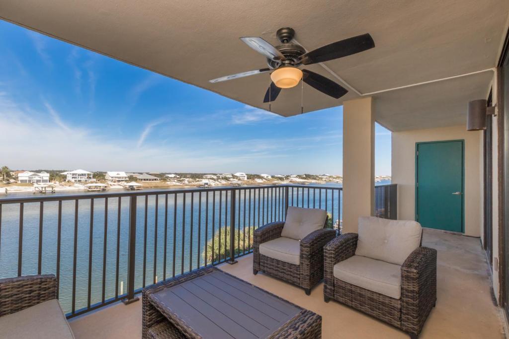 奥兰治比奇Ole River Hideway, Orange Beach, Updated 2 Bedroom Waterfront Condo, Wind Drift的阳台配有2把椅子和吊扇