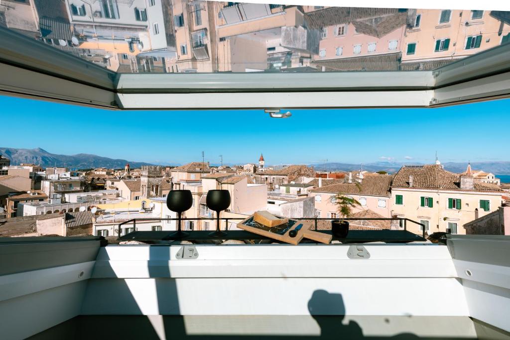 科孚镇Vailato Loft Suites的把城市的照片从窗口拍下来的人的影子