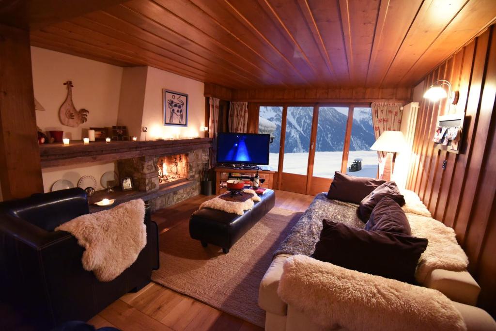 韦尔比耶Ski-in, Chalet-style appt - 1 Min Walk to Lift的带沙发、电视和壁炉的客厅