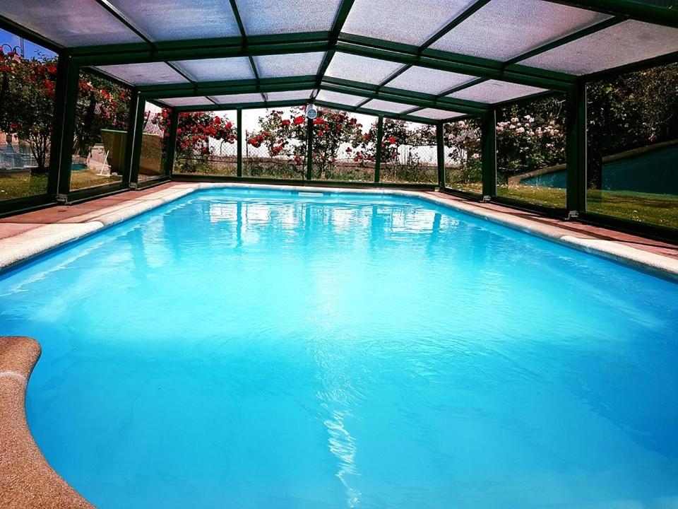 贝洛拉多Albergue Cuatro Cantones (Exclusivo para Peregrinos)的一个带天篷的大型蓝色游泳池
