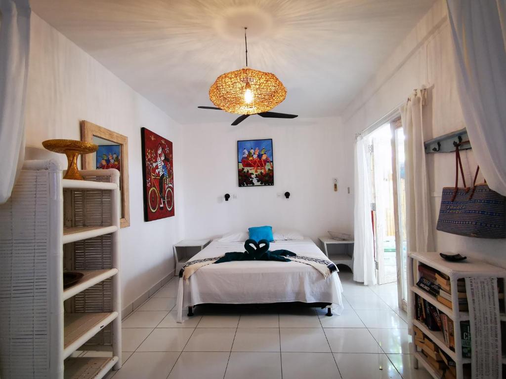 吉利特拉旺安Sahara Sands Guest House - Gili Trawangan的一间卧室配有一张床和一个吊灯