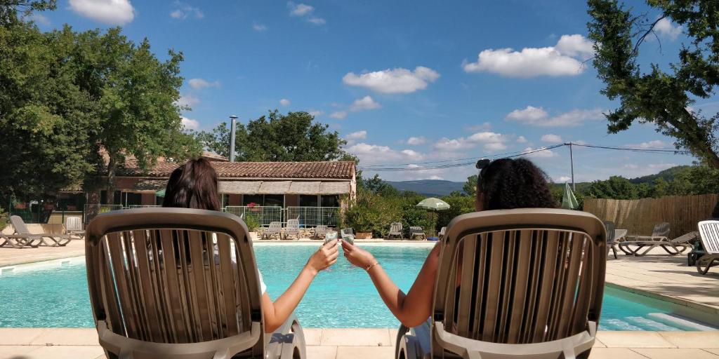 圣萨蒂南艾普特布兰科斯谢那假日公园的两个妇女在游泳池边坐在椅子上