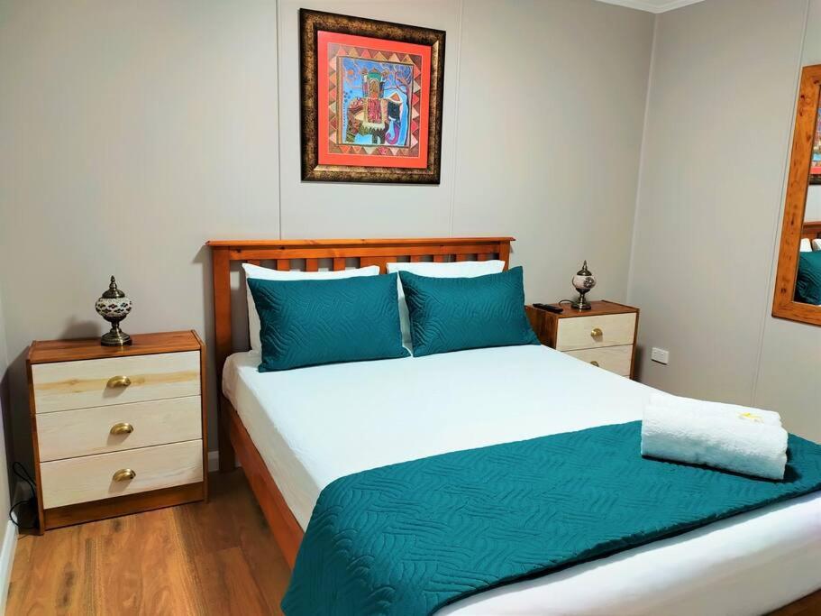 汤斯维尔Cute City Cottage - 2 Bedroom - The Strand的一间卧室配有一张带蓝色枕头的大床