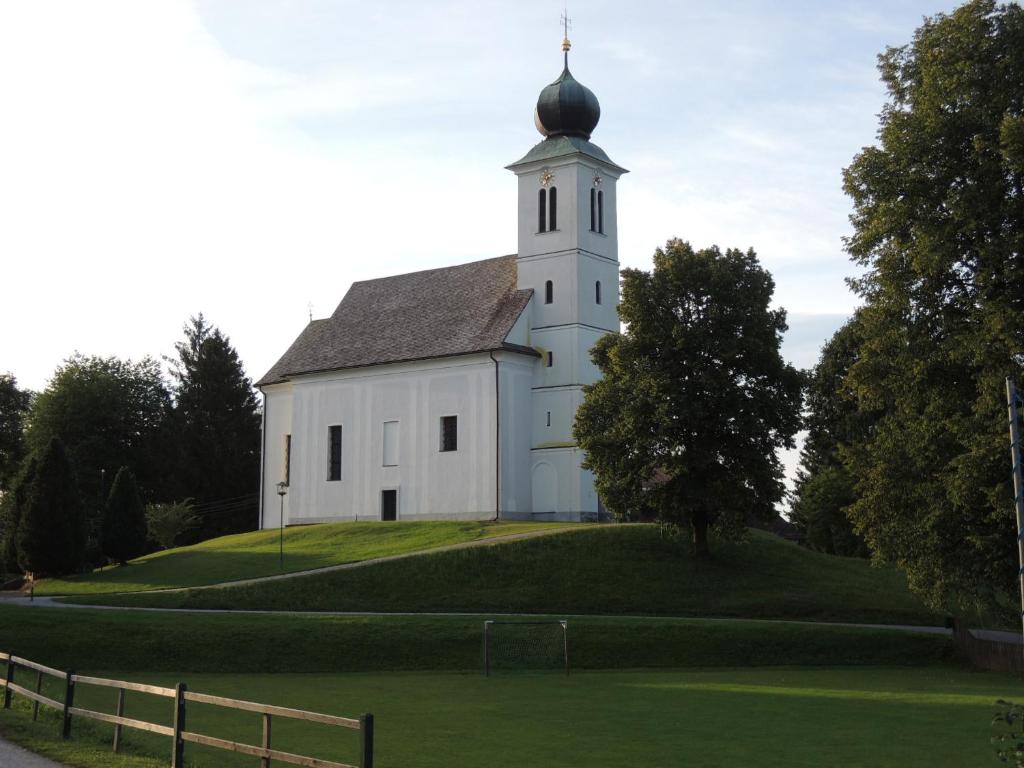 Sankt Oswald ob EibiswaldFamilienglück in der Weststeiermark的山顶上一座白色教堂