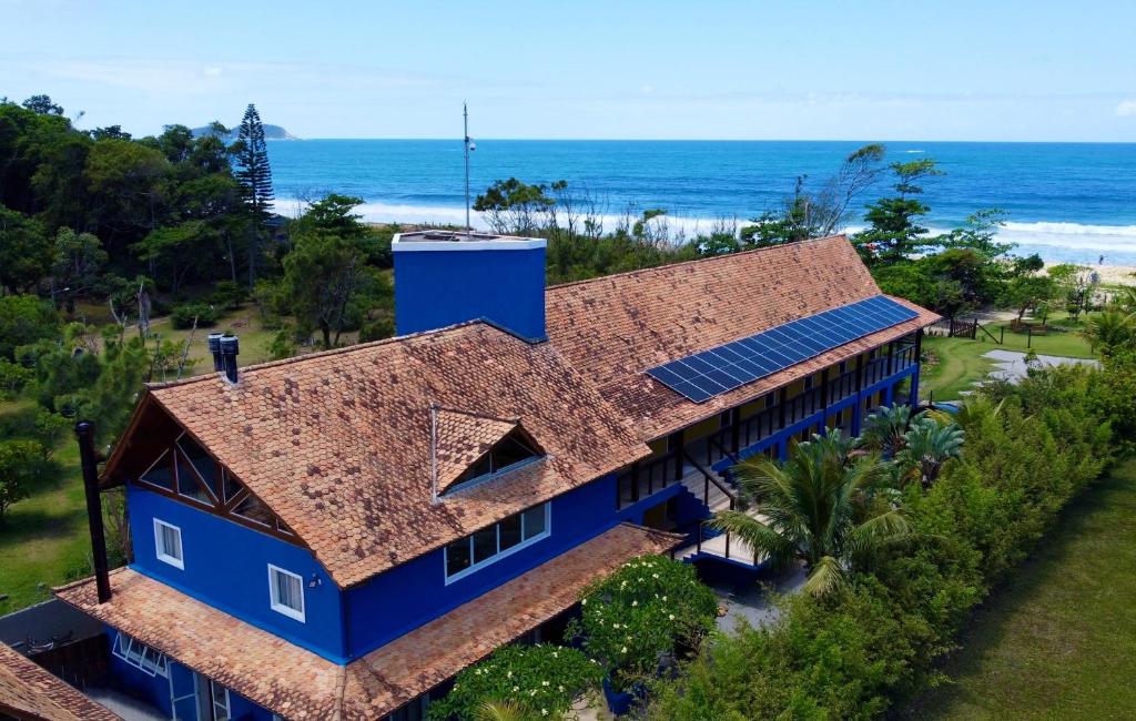 弗洛里亚诺波利斯Pousada Penareia Floripa的蓝色房子的顶部景色,背景是大海